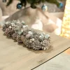 Centre de table de Noël effet givré avec pommes de pin, baies et 4 bougeoirs en verre